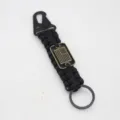 Detailed view of outdoor survival paracord keychain with eagle hook and US flag metal tag. - Black