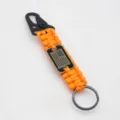 Outdoor survival paracord keychain with US flag metal buckle and portable design. - Orange