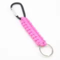 Llavero de paracord rosa con mosquetón negro y anillo metálico, diseño trenzado resistente. - Rosa