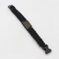 Black paracord survival bracelet with tactical buckle and American flag metal plaque detail. - Black