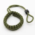 Detailed close-up of the army green paracord camera wrist strap showing durable weaving. - Army Green