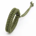 Close-up of the army green handmade paracord bracelet showing fine weaving and adjustable ends. - Army Green