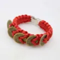 Red paracord bracelet detailed closeup featuring traditional copper five emperor coins and metal buckle. - Red