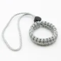 Paracord camera wrist strap detail, durable woven survival bracelet with black buckle. - No. 251