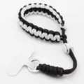 Zwart-witte paracord telefoonpolsband met verstelbare gesp en bevestigingslipje. - Zwart+Wit