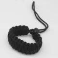 Detailed close-up of a black paracord camera wrist strap, showing tight weave and durable texture. - Black