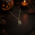 Close-up detail shot of a gold spider pendant necklace featuring a sparkling dark stone. - Spider Necklace / Single Necklace / Black