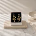 Vintage gold snake earrings with black teardrop gemstone in luxury jewelry gift box. - Vintage Snake Stud Earrings (miou-488) / Black