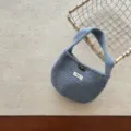 Nahaufnahme der weichen Strick-Minihandtasche, die feine Textur und den Hornknopf zeigt. - Passend für 3-10 Jahre / Blau
