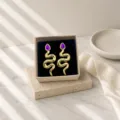 Detailed close-up view of the vintage snake-shaped earrings featuring purple gemstone inlay. - Vintage Snake Stud Earrings (miou-488) / Purple