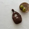 Brown knitted toddler crossbody bag detail with knotted strap and cute woven label. - Crossbody Bag / Coffee