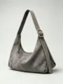 Graue Wildleder Umhängetasche für Damen, stilvolle Hobo Tasche mit Nieten und Reißverschluss. - Hellgrau