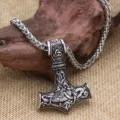 Detailed close-up of Viking Mjölnir Thor hammer pendant necklace with intricate Nordic carvings. - Antique Silver