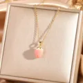 Primer plano de collar dorado con colgante de fresa rosa y detalles finos de joyería elegante. - Fresa 3 - Dorado