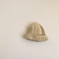 Close-up detail of soft beige knit baby beanie hat, warm winter accessory for kids. - One Size / Beige (Child)