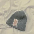 Primo piano del berretto in maglia grigia con etichetta, dettaglio accessorio morbido - Bambini Grigio