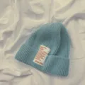 Primo piano di berretto in maglia azzurro cielo con elegante toppa di lettere, caldo. - Bambini Grigio Bluastro