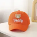 Gedetailleerde opname van een oranje baby honkbalpet met schattig berenborduurwerk. - 48-52cm / Oranje