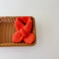 Detail view of the cozy orange knit children scarf, featuring a simple cross design for kids. - Orange