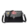 Zwarte lederen schoudertas voor dames met gebosseleerd bloemenpatroon, stijlvolle crossbody tas. - Zwart