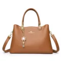 Braune grosse Handtasche mit Tragegriffen und elegantem Blumenanhanger fur Damen. - Gelbbraun