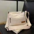 Beige multi-compartment canvas crossbody shoulder bag for casual everyday use and outdoor travel. - White