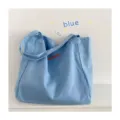 Casual light blue canvas tote bag with embroidered letters, perfect for daily shopping or school use. - Zippered Inner Pocket / Blue