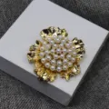 Gros plan d'une broche fleur dorée vintage avec perles, accessoire bijou élégant femme. - Broche / Or