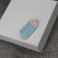 Gros plan de broche en émail créatif au design bleu et rose, accessoire exquis. - Style C