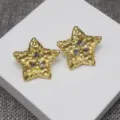 Gros plan de boucles d'oreilles étoile dorées style vintage avec des cristaux scintillants. - Boucles d'oreilles clous