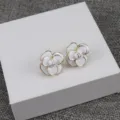 Boucles d'oreilles clous camélia blanc émail bord doré élégant style rétro français. - Blanc