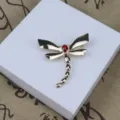 Vue de détail d'une broche libellule en alliage émaillé vintage avec pierre rouge, accessorio chic. - Rouge
