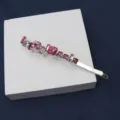 Vue détaillée de barrette à cheveux élégante avec des strass roses brillants en argent. - Lettre C