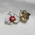 Gros plan détaillé de boucles d'oreilles fleur d'orchidée en émail vintage avec perle. - Boucles d'oreilles à clip