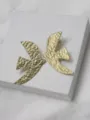 Gros plan détaillé de boucles d'oreilles hirondelle texturées dorées, bijoux design élégants. - Boucles d'oreilles clous / Or
