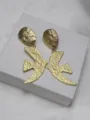 Gros plan de boucles d'oreilles rétro dorées texturées en forme d'oiseau, design élégant. - Boucles d'oreilles à clip / Or