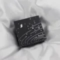 Black square gift box with silver cosmic galaxy design, elegant jewelry packaging detail. - Paper Box