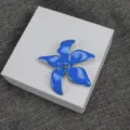 Gros plan de la broche iris en émail bleu montrant des pétales délicats et des détails. - Bleu