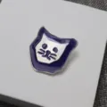 Dettaglio spilla gatto in smalto con bordo viola e viso argento testurizzato, finemente lavorata. - Gatto Viola