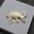 Elegante spilla a forma di cervo dorato con macchie di smalto bianco e dettagli unici. - Cervo
