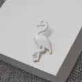 Vue detaillee du charmant brooch en email blanc flamant rose, accessoire elegante. - Blanc