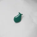 Gros plan détaillé du charmant pin's en émail vert en forme de poire pour accessoires. - Poire