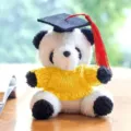 Dettaglio in primo piano del peluche panda di laurea con maglione giallo e cappello. - Ciondolo Panda Cappello da Dottore / Maglioni gialli