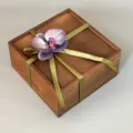 Wooden gift box detail, ornate with green ribbon and purple orchid, premium packaging. - Purple Orchid + Green Ribbon + Wooden Box / 20x20x10CM