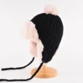 Gemütliche schwarze Strickmütze mit rosa Plüschfutter und süßem Bommel für kalte Tage. - Einheitsgröße (56-58cm) / Schwarz