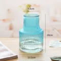 Vase en verre bleu avec design à rayures verticales, idéal pour décoration florale. - Bleu