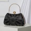 Elegant black rhinestone evening clutch bag featuring a gold metal handle and crystal floral design. - Black
