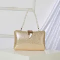 Elegant gold glitter evening clutch bag featuring a leaf clasp and pearl handle. - Gold