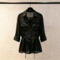 Black sheer chiffon utility shirt featuring gold buttons, elegant lapels and a waist drawstring. - Black