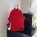 Lässiger minimalistischer roter Nylon Mini Rucksack für Damen, leichte multifunktionale Tasche. - Mit Anhänger / Rot
